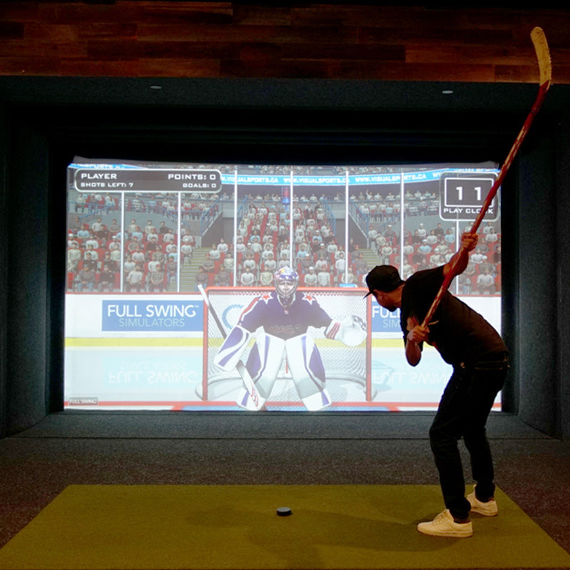 Man playing hockey on Full Swing simulator